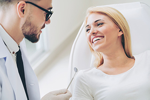 Image of a woman smiling at dental professional.