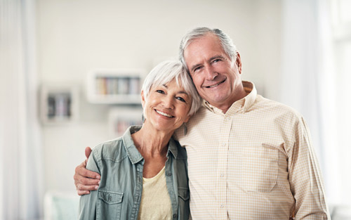 Older couple hugging and smiling at St. Louis Prosthodontics in St. Louis, MO.